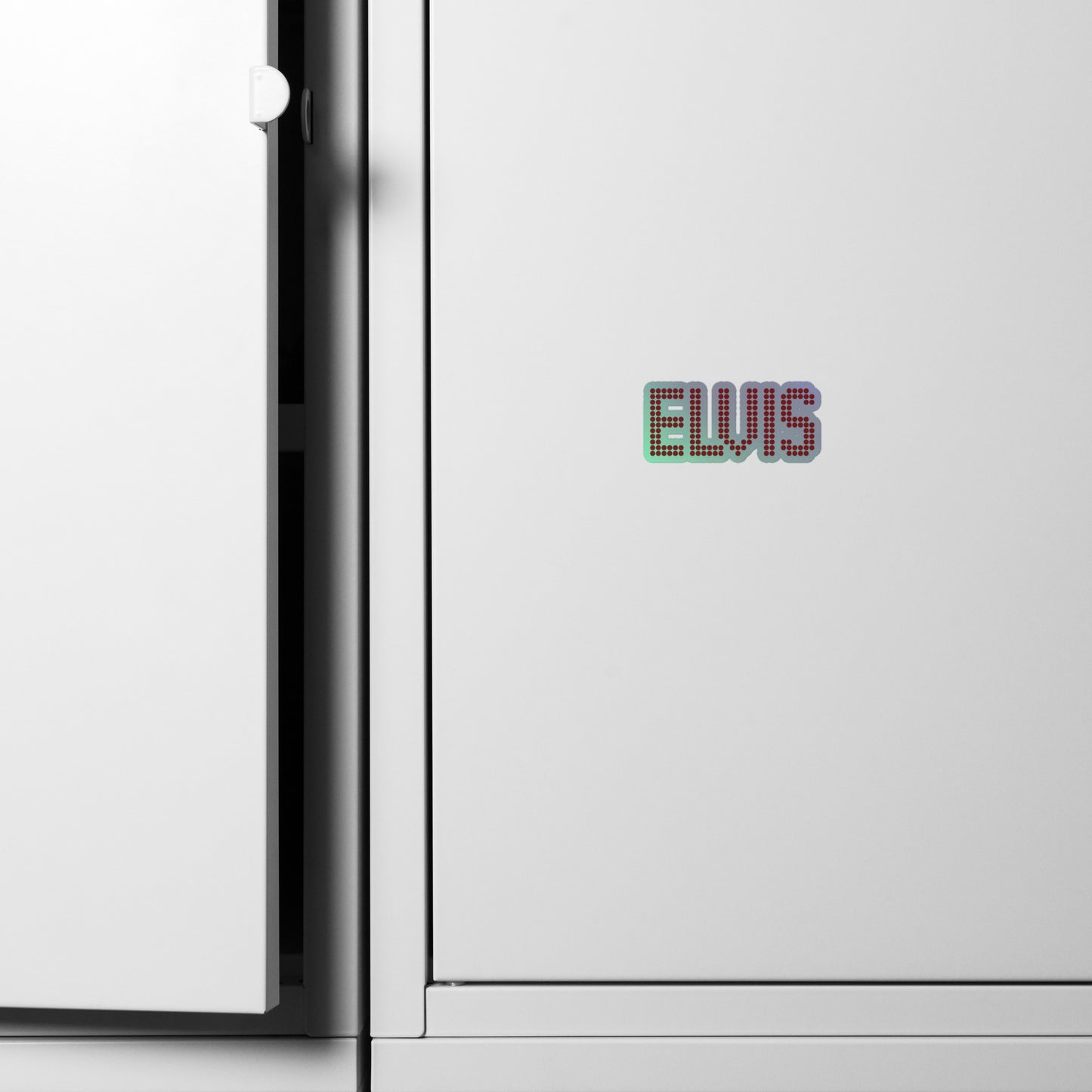 A close-up of a white cabinet with a small colorful 'ELVIS' text decal on the front, next to the open door hinge.